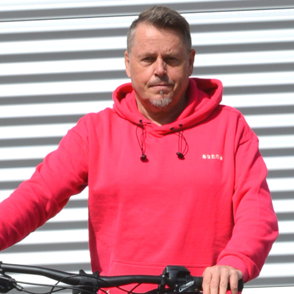 Mann mit Fahrrad vor Garage